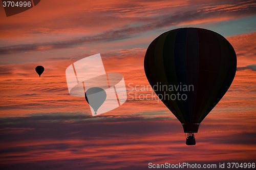 Image of Hot-air balloons floating among clouds at dawn