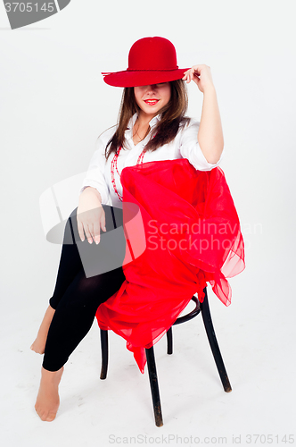 Image of Young attractive woman with hat on chair