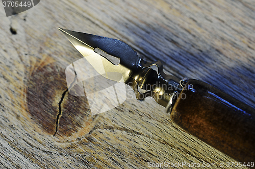 Image of closeup of fountain pen on wooden 