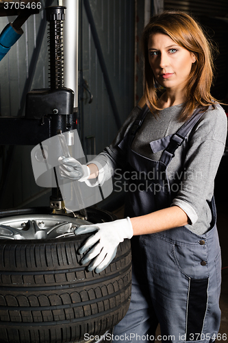 Image of Young trainee changing  car tyre 