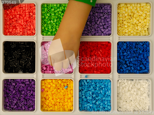 Image of Child playing with toy pearls