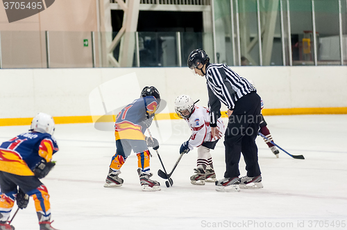 Image of Puck playing between players of ice-hockey teams