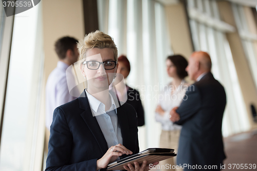 Image of business woman  at office with tablet  in front  as team leader