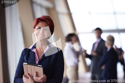 Image of business woman  at office with tablet  in front  as team leader