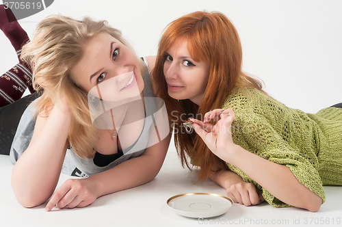Image of Two attractive girls lie and have fun