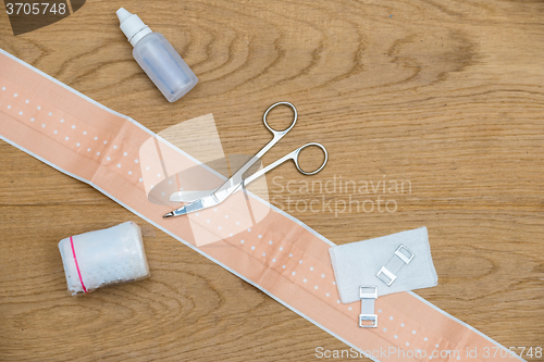 Image of Medical Bandage And Scissors On Wooden Table