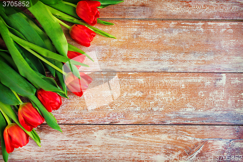 Image of close up of red tulips on wooden background