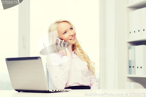 Image of smiling businesswoman calling on smartphone