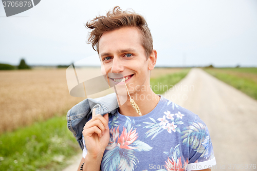 Image of smiling young hippie man on country road