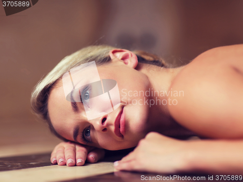 Image of young woman lying on hammam table in turkish bath