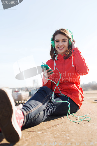 Image of happy young woman with smartphone and headphones