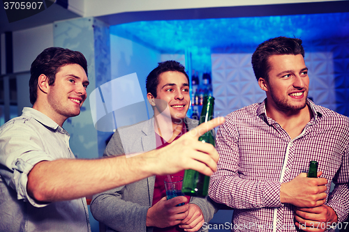 Image of group of male friends with beer in nightclub