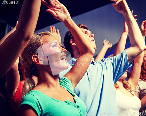 Image of smiling friends at concert in club