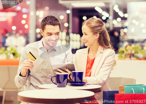 Image of couple with tablet pc and credit card in mall