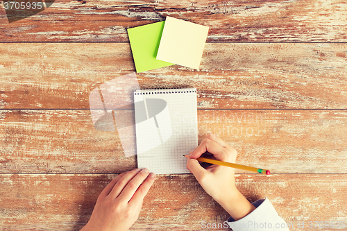 Image of close up of hands with notebook and stickers