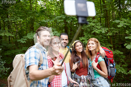 Image of friends with backpack taking selfie by smartphone