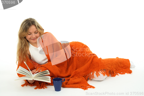 Image of Cozy girl reading a book, smiling