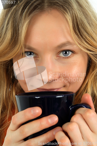 Image of Charming young woman drinking tea