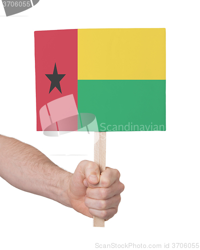 Image of Hand holding small card - Flag of Guinea Bissau