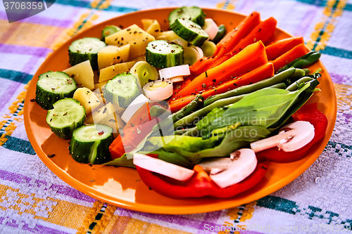 Image of Ladle of steamed freshly harvested young vegetables including crinkle cut sliced carrots, peas and potato batons