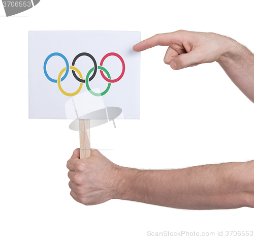 Image of Hand holding small card - Flag of the Olympic games