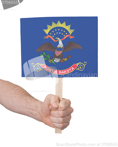 Image of Hand holding small card - Flag of North Dakota