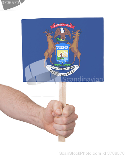 Image of Hand holding small card - Flag of Michigan