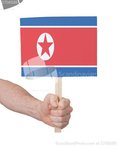 Image of Hand holding small card - Flag of North Korea