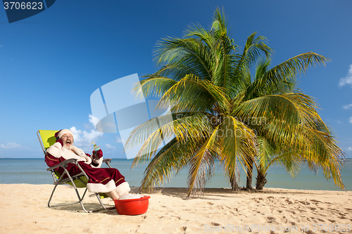 Image of Santa Claus sitting in deck chair on beach