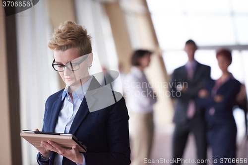 Image of business woman  at office with tablet  in front  as team leader