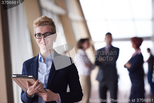 Image of business woman  at office with tablet  in front  as team leader