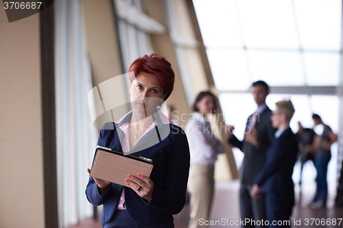 Image of business woman  at office with tablet  in front  as team leader