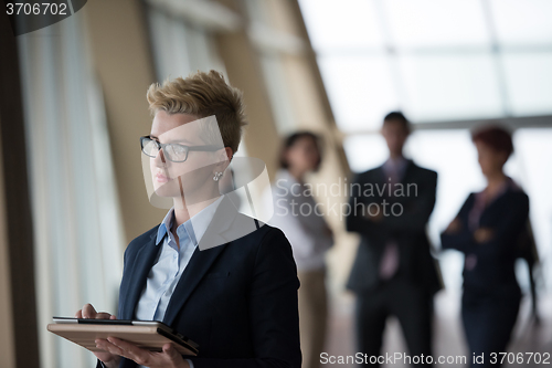 Image of business woman  at office with tablet  in front  as team leader