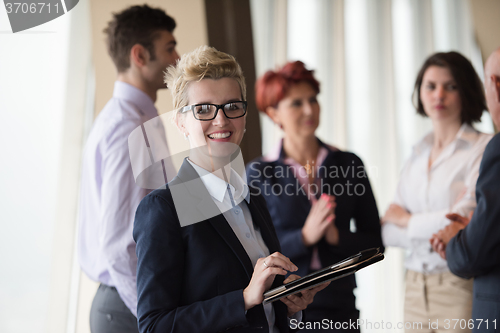 Image of business woman  at office with tablet  in front  as team leader