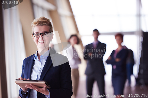 Image of business woman  at office with tablet  in front  as team leader