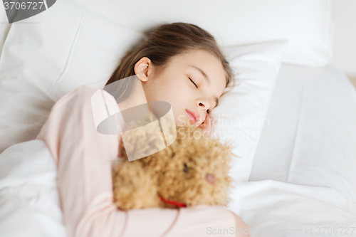 Image of girl sleeping with teddy bear toy in bed at home