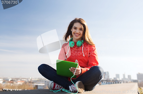 Image of happy young woman with tablet pc and headphones