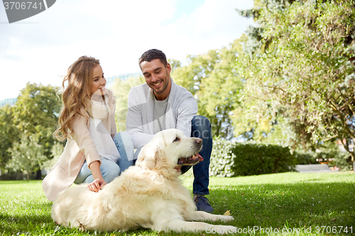 Image of happy couple with labrador dog walking in city