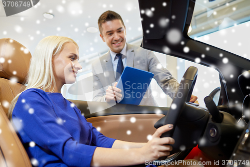 Image of happy woman with car dealer in auto show or salon