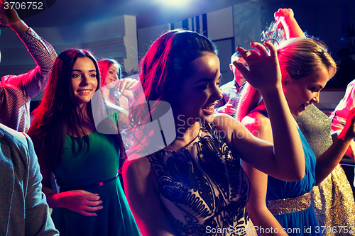 Image of smiling friends dancing in club