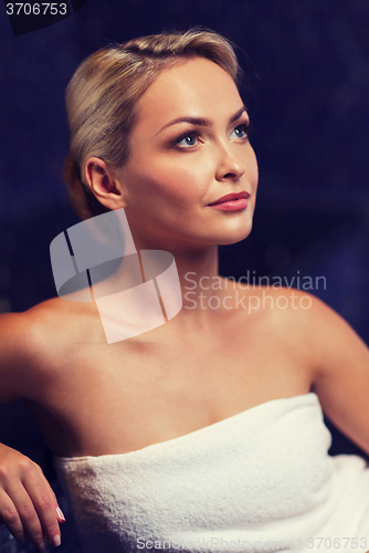 Image of beautiful young woman sitting in bath towel
