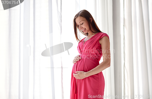 Image of happy pregnant woman with big tummy at home