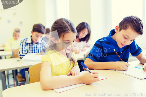 Image of group of school kids writing test in classroom