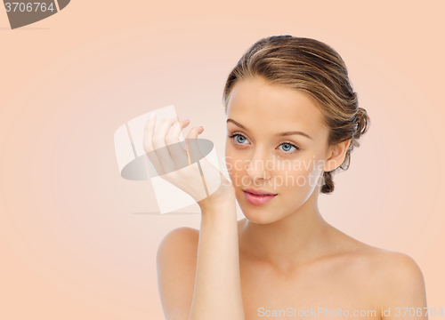 Image of woman smelling perfume from wrist of her hand