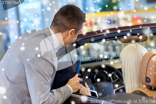 Image of woman and car dealer with tablet pc in auto salon