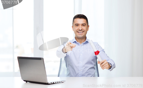 Image of man with diploma and laptop pointing finger