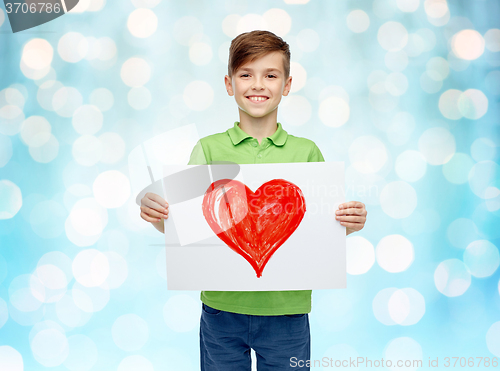 Image of happy boy holding drawing or picture of red heart