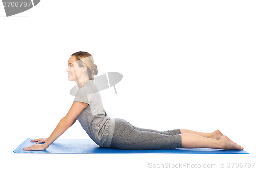 Image of woman making yoga in dog pose on mat