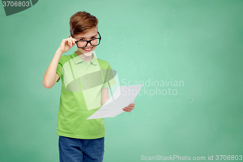 Image of happy boy in eyeglasses holding school test result