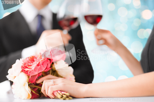 Image of happy engaged couple with flowers and wine glasses